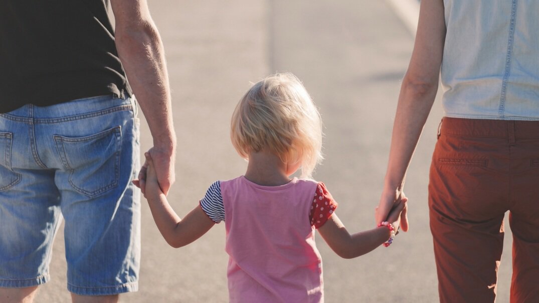 Child holding parent hands