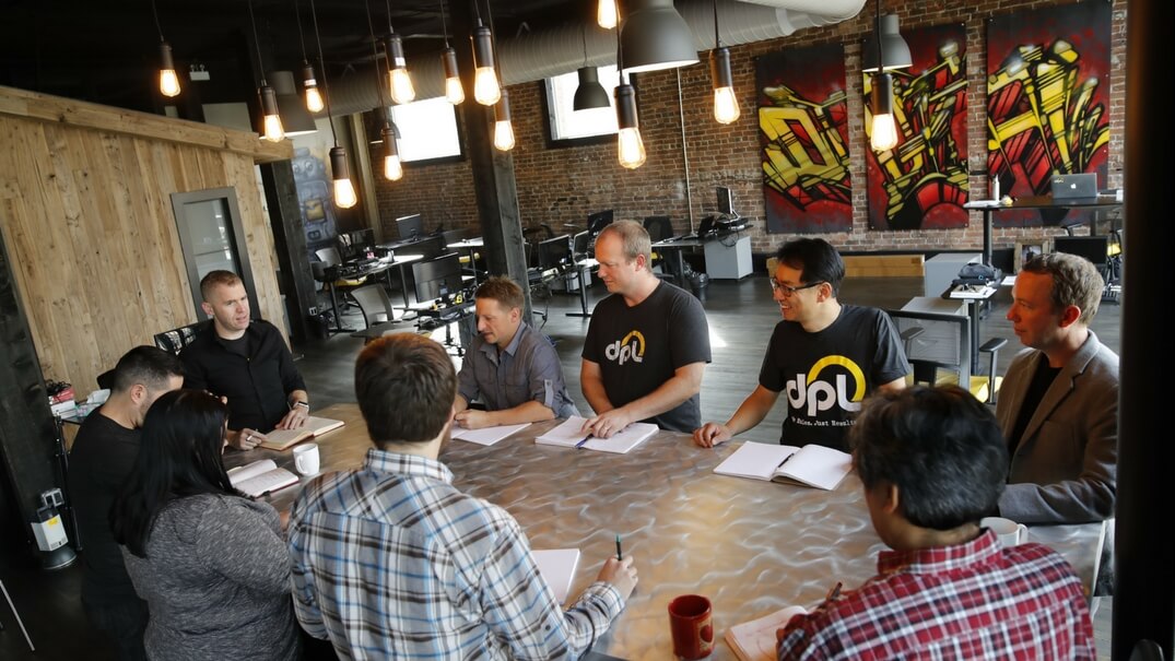 DPL team sitting around a desk in a meeting