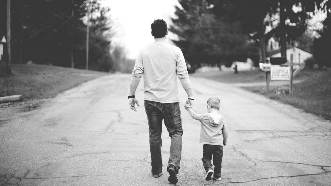 Father and son walking down a road